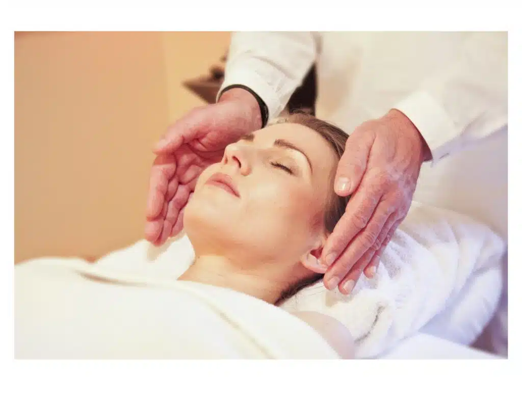 Women on bed receiving a facial massage.