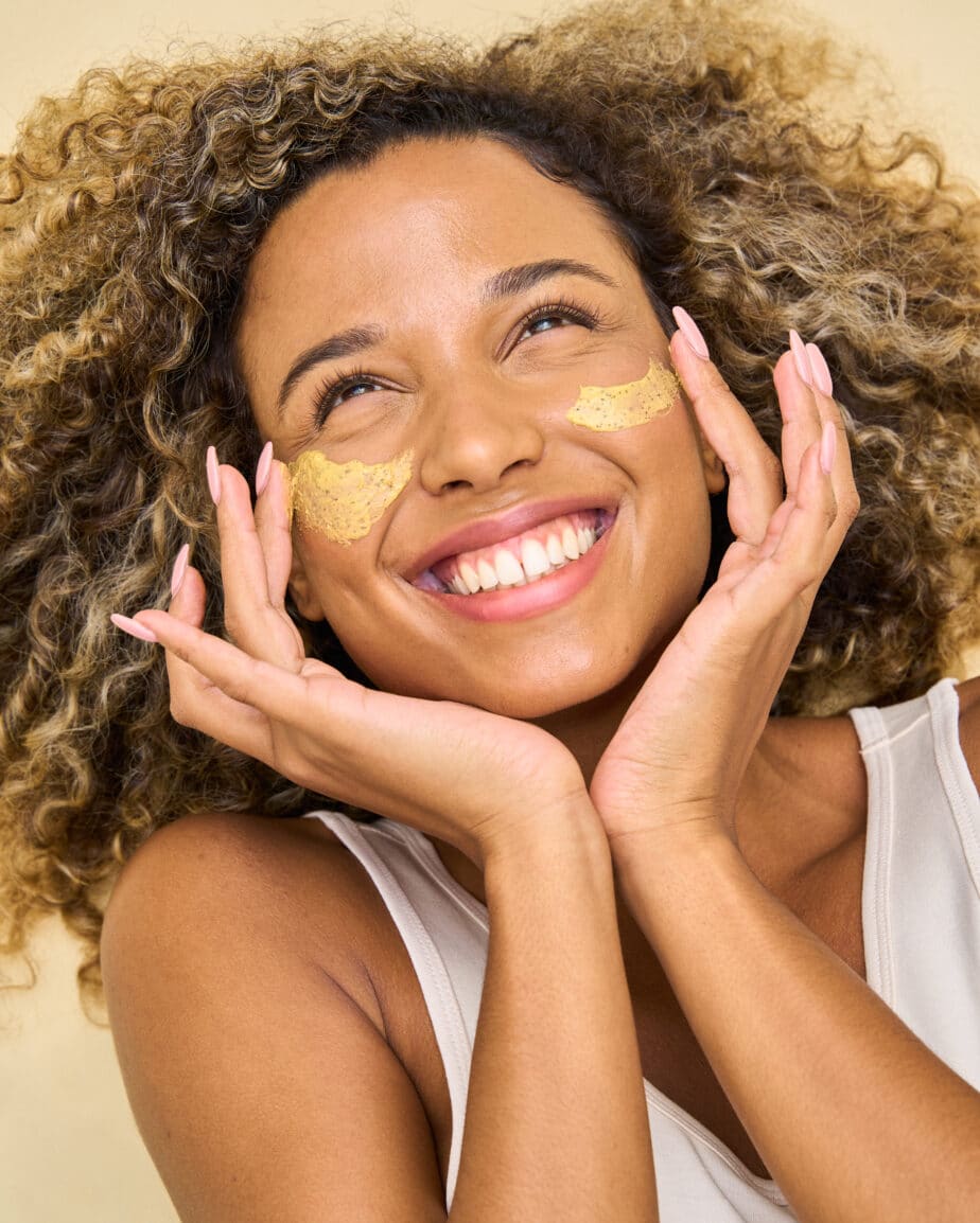 Woman smiling looking up with cream on the cheek