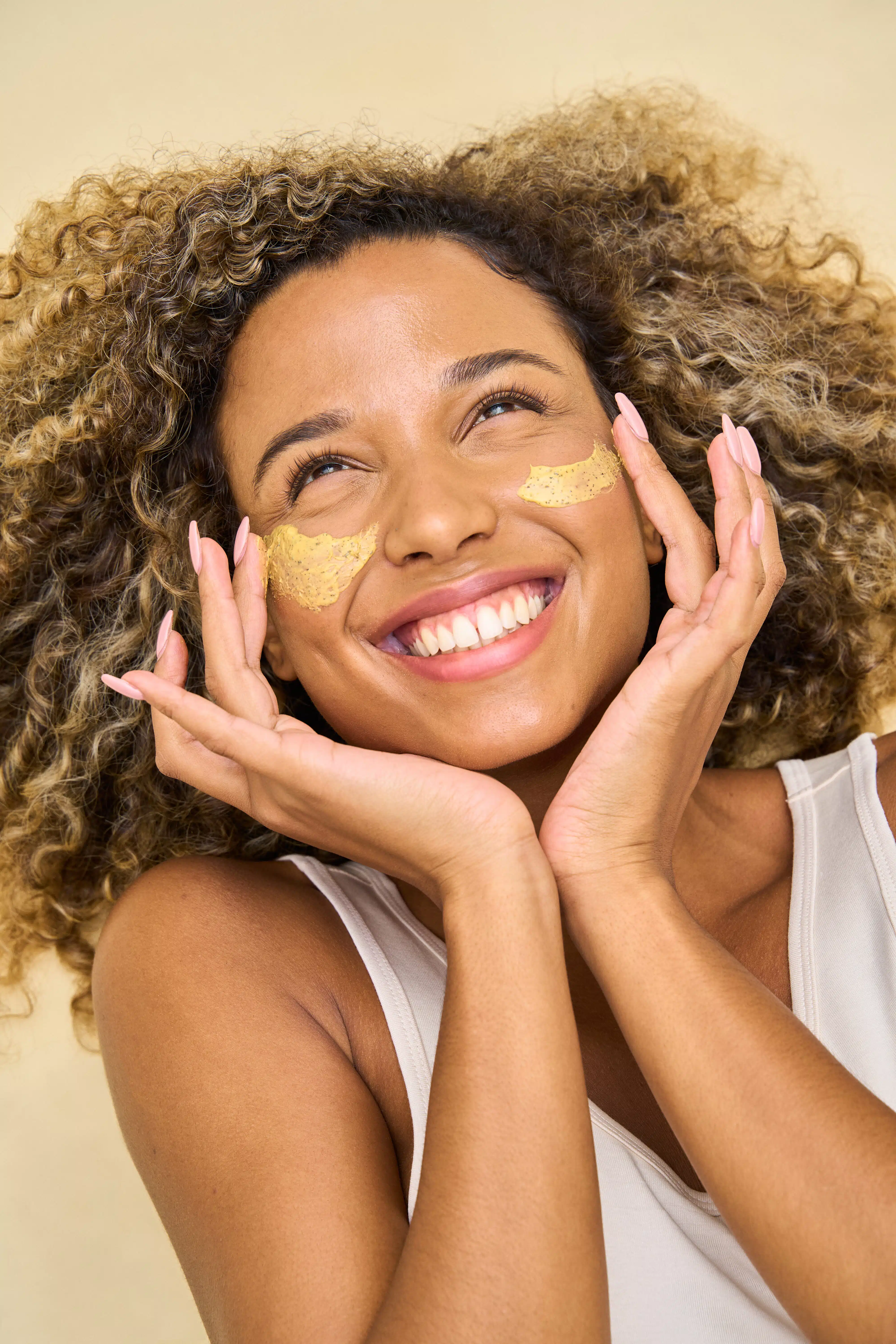 Woman smiling looking up with cream on the cheek